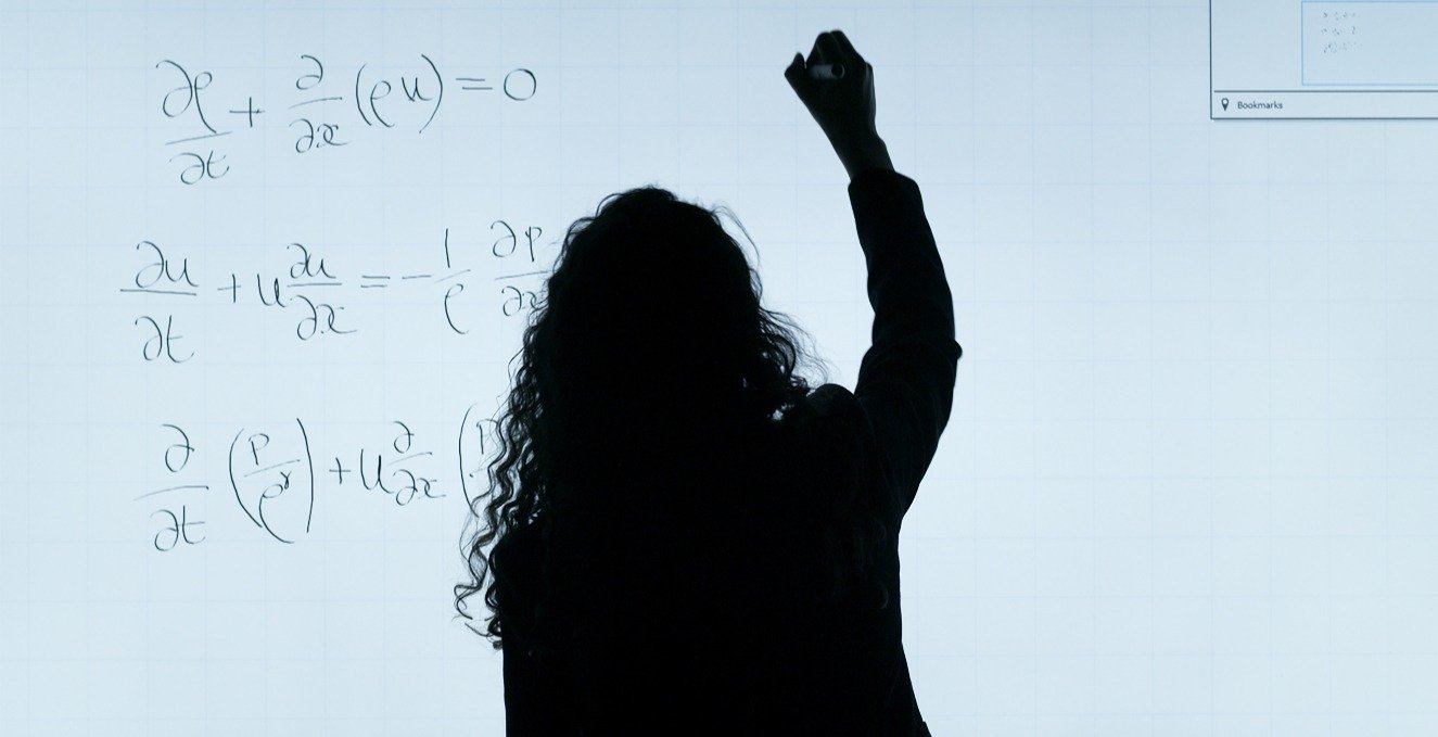 professor writing a formula on white board