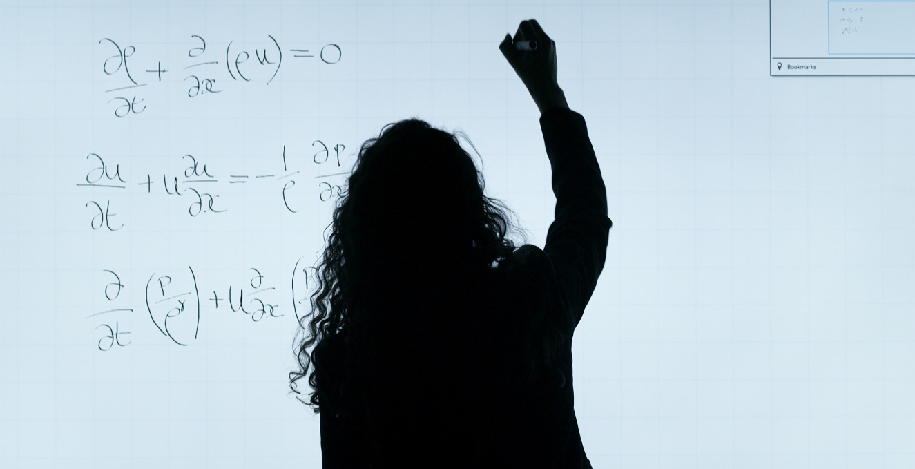 professor writing a formula on white board