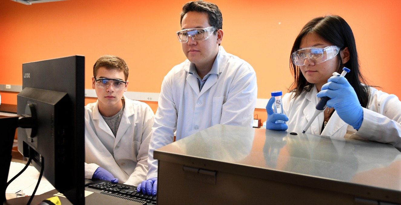 Three researchers reviewing research information